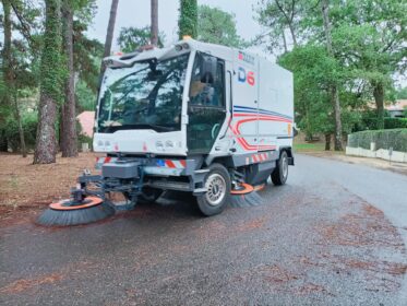 Image de balayeuse thermique extérieure en action sur une route