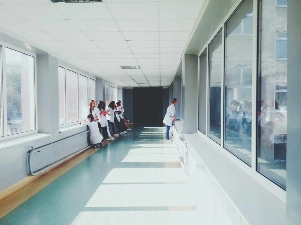 woman-in-white-shirt-standing-near-glass-window-inside-room-127873